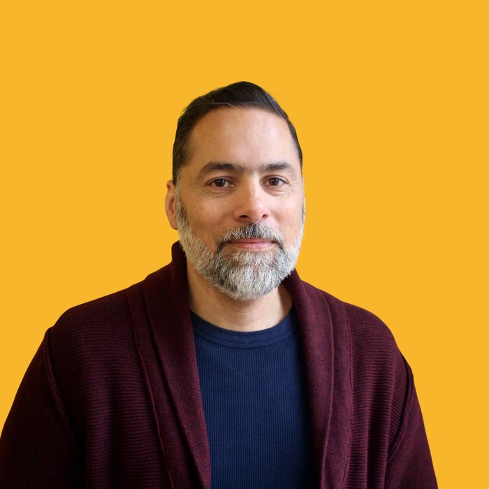 Portrait of a New Haven business owner against a gold backdrop
