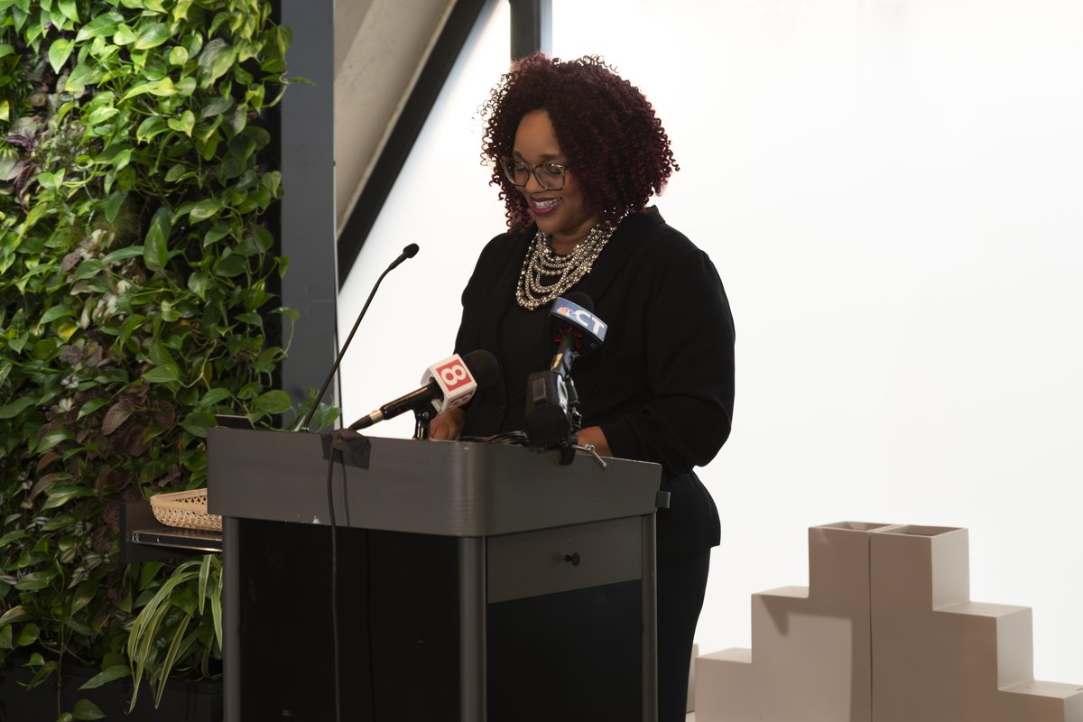 A speaker addressing attendees from a podium at a Center information session